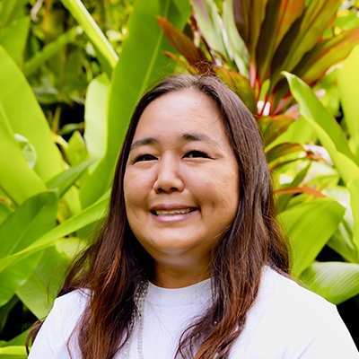 Dental Hygienist Erin Smiling In Front Of Greenery