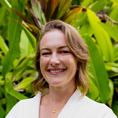 Insurance Coordinator Sofiya Smiling In Front Of Greenery